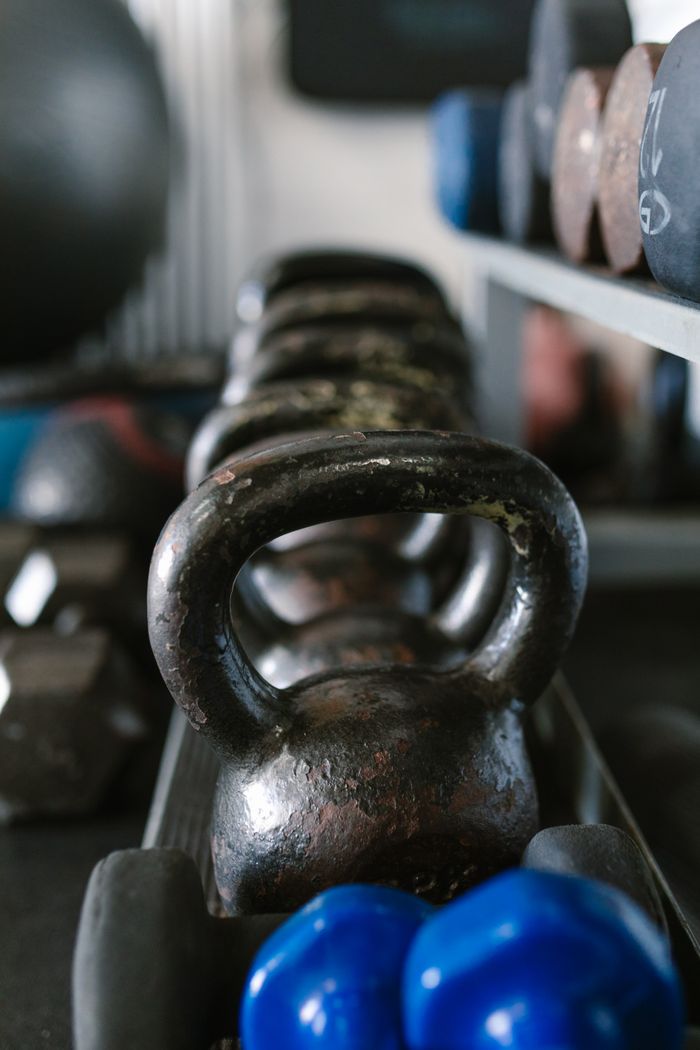 services-02 A close view of kettlebells and weights, showcasing essential gym equipment for strength training.