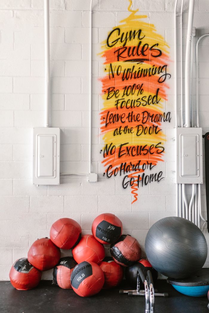 Crafting Captivating Headlines: Your awesome post title goes here Gym wall with motivational quotes and exercise balls against a white background.